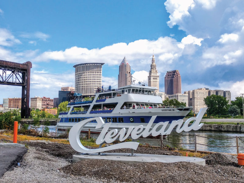 a sign "cleveland" on a mount, with the goodtimeiii boat in the background